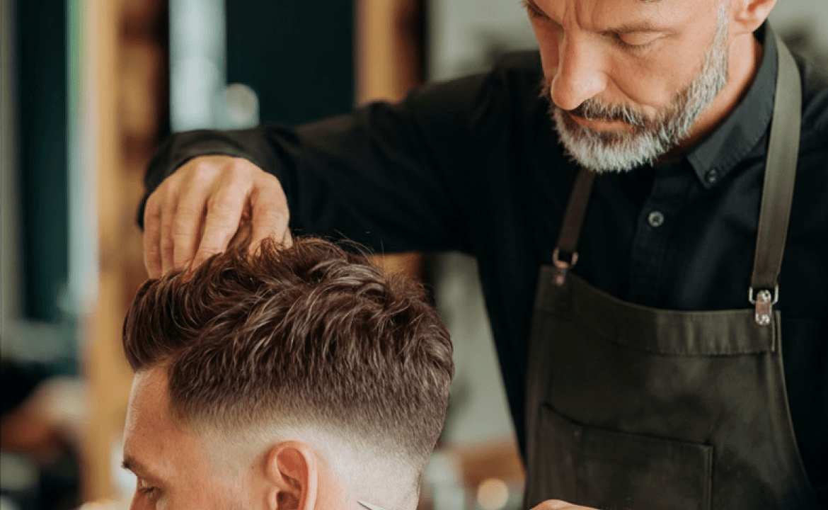 Barbeiro finalizando um corte masculino